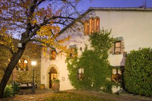 a white house with a tree in front of it at Can Barrina in Montseny