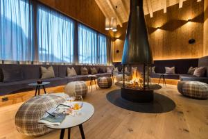 a living room with a fireplace and a couch at Adler Damüls Gasthof Hotel in Damuls