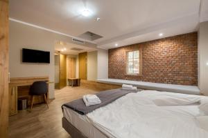 um quarto com uma cama grande e uma parede de tijolos em Hotel Vinnica em Wieliczka