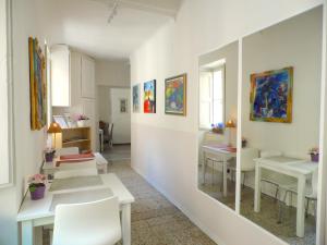 a room with white tables and chairs and paintings at Casa Alba in Lucca