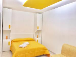 een slaapkamer met een geel bed en een stoel bij B&B Fratelli Tommasini Salerno in Salerno