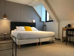 Un pat sau paturi într-o cameră la Hotel de France