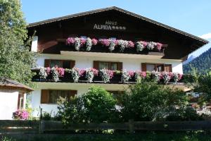 un edificio con flores a un lado. en Haus Alpina en Häselgehr