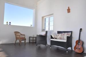 una sala de estar con sillas y una guitarra. en Casa Serra e Mar, en Mafra