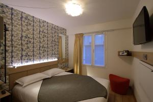 パリにあるホテル オール レ リュミエールの小さなベッドルーム(ベッド1台、窓付)