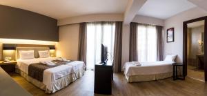 A bed or beds in a room at Philippos Xenia Hotel