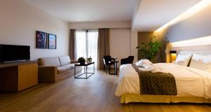 um quarto de hotel com uma cama e uma sala de estar em Philippos Xenia Hotel em Serres