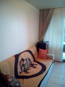 uma sala de estar com um sofá com um cobertor em Flat Resort Marulhos em Porto de Galinhas