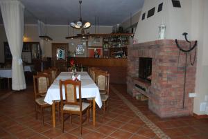 a dining room with a table and a brick fireplace at Hotel Anka in Słubice