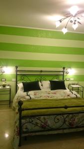 a bedroom with green striped walls and a bed at Affittacamere Villa Giulia in Moneglia