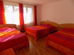 een hotelkamer met 2 bedden en een raam bij Семеен Хотел Вит in Teteven