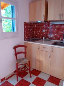カラ・ネラにあるMairi Lina Studiosのキッチン(赤い椅子、シンク付)