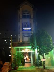 a building at night with a building with a tree in front at Hai Dang Hotel in Ho Chi Minh City