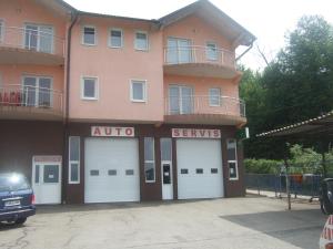 a large building with four garage doors in a parking lot at Rooms Zebax in Sarajevo