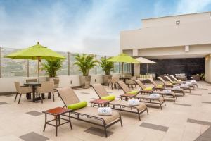 a row of chairs and tables and umbrellas on a patio at Wyndham Guayaquil, Puerto Santa Ana in Guayaquil