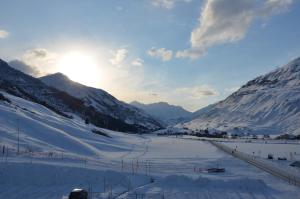 a snow covered mountain with the sun in the background at Hotel Aurora in Andermatt
