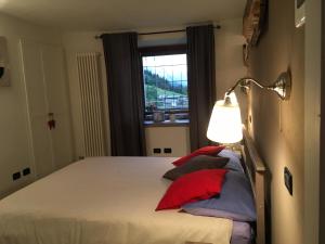 a bedroom with a bed with a lamp and a window at Maison Grivon Incanto e Vista sulla Valle in Charvensod