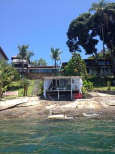 a house on the shore of a body of water at Cabana Do Mar in Angra dos Reis