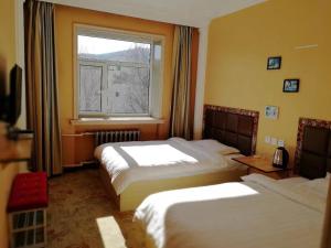 una camera d'albergo con due letti e una finestra di Yabuli Sunshine Sports Hotel a Shangzhi