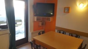 a room with a table and a tv on the wall at Rogla app Jerebika 11 in Zreče