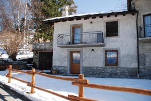 a house with a wooden fence in the snow at Maison Grivon Incanto e Vista sulla Valle in Charvensod