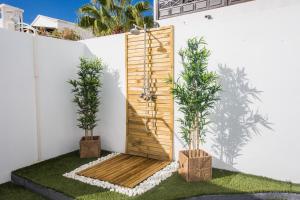 un jardín con 2 macetas y una puerta de madera en Palm Villa, en Puerto del Carmen