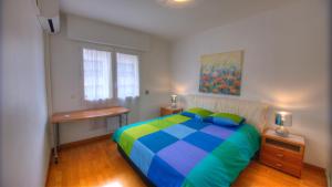 a bedroom with a colorful bed and a desk at 2 Pièces 57 Rue d'Antibes proche Palais in Cannes