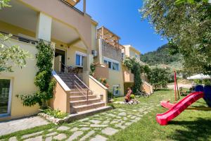 a house with a red slide and a playground at Antheon Villas in Chrysi Ammoudia
