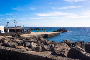 プエルト・デル・カルメンにあるPalm Villaの岩の桟橋からの海の景色