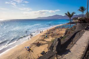 una playa con multitud de personas y el océano en Palm Villa en Puerto del Carmen