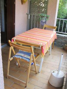 una mesa a rayas y sillas en un patio en 2VAD13 Studio proche centre-ville, en Collioure