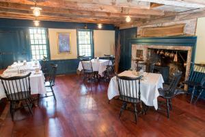 ein Esszimmer mit Tischen und Stühlen sowie einem Kamin in der Unterkunft Three Chimneys Inn in Durham