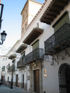 a white building with balconies and a clock tower at Cuevas el Balcón de Orce in Orce