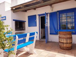a blue bench sitting in front of a house at Pondok in Paternoster