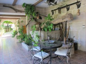 a patio with a table and some plants on the wall at Os Areeiros Turismo Rural & Bodega in Santa Cristina de Cobres