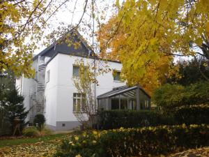 a white house with a black roof at Hotel Landhaus Schlachtensee in Berlin