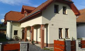 una pequeña casa blanca con techo rojo en Apartmány MarAqua, en Liptovský Trnovec