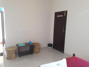 Habitación con armario negro y mesa. en Squirrel Nest Guest House en Mahabalipuram