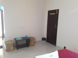 a room with a black cabinet and a table at Squirrel Nest Guest House in Mahabalipuram