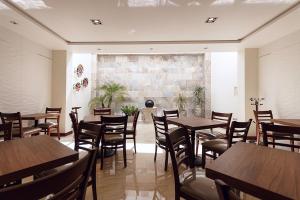 a restaurant with wooden tables and chairs and a brick wall at Hotel Maria Fernanda Inn in Zitácuaro