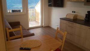 a kitchen with a table and chairs and a balcony at Gruberhof in Lagundo