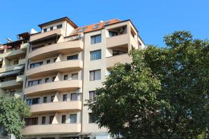 サンダンスキにあるPanoramic Apartmentの木が目の前に立つ高層アパートメント