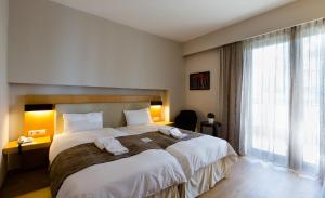 A bed or beds in a room at Philippos Xenia Hotel