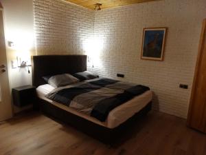 a bedroom with a large bed with a brick wall at Ferienwohnung "Am Rothaarsteig" in Winterberg