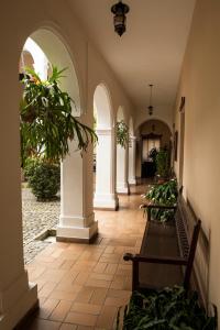 ポパヤンにあるHotel La Plazuelaのアーチとベンチのある廊下