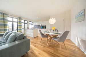 uma sala de estar e cozinha com uma mesa e um sofá em Design Apartments - "Am Schlosspark" Adults Only em Potsdam