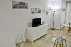 Televízia a/alebo spoločenská miestnosť v ubytovaní WonderStays Apartamentos Vela
