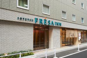 a building that has a sign on the side of it at Sotetsu Fresa Inn Ginza Sanchome in Tokyo