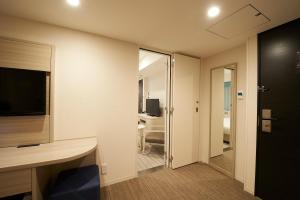 a room with a door leading to a bathroom at Sotetsu Fresa Inn Ginza Sanchome in Tokyo