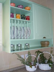 a cupboard with plates and bowls and two baskets at Quinta Vale do Nox in Serrazes